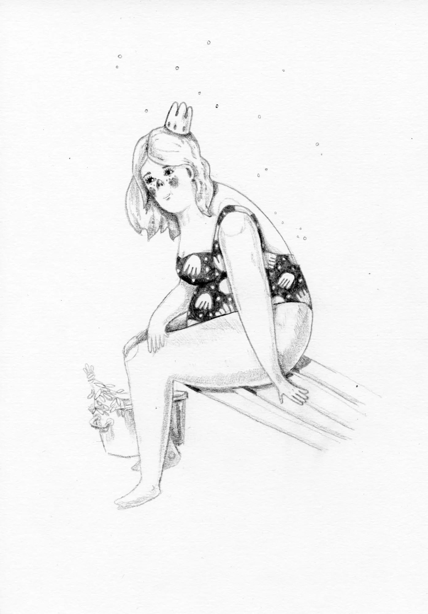 Girl in a spotted bikini sits knees-up on a striped board, small dots floating in the air around her